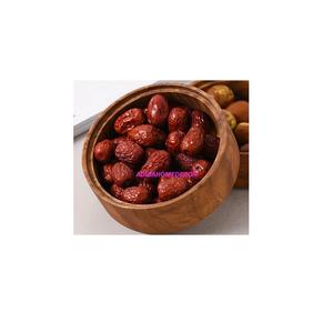 The gentle lighting accentuates the plumpness of the fruit and the smoothness of the wooden bowl - Product Image 1