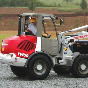 รถตักล้อยาง Takeuchi TW60C2HS ระดับความน่าเชื่อถือสูงสุด พร้อมห้องโดยสารแบบปิดที่สะดวกสบาย โดดเด่นด้วยมอเตอร์หลักและส่วนประกอบ PLC - Product Image 1