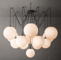 Lustre de luxe moderne en laiton et verre mat composé de plusieurs lampes sphériques pour escalier de maison d'hôtel à haut plafond