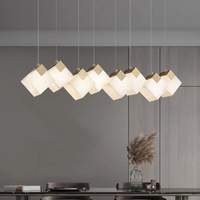 Suspension linéaire à six lampes de style nordique en albâtre avec abat-jour carré et cadre doré, idéale pour l'éclairage d'îlot de cuisine.