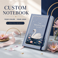 Agenda LABON personnalisé Swan Lake, couverture rigide en lin bleu poussière, titre en police blanche, cygnes, nénuphars, bords dorés, bande élastique marine