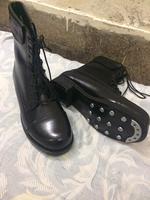 une paire de bottes en cuir noir, peut-être des bottes de pilote ou de pilote de ligne