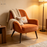Fauteuil de salon rétro en tissu orange, confortable et rembourré, idéal pour la lecture dans une chambre ou un appartement