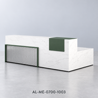 Bureau de réception en L en bois aspect marbre blanc avec accent vert foncé et façade grise côtelée pour projets de hall d'accueil de bureau moderne