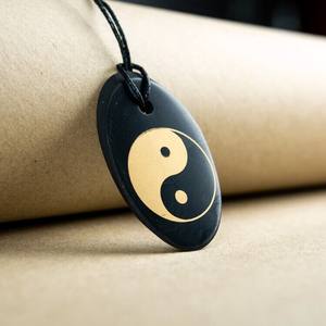 Colgante ovalado pulido de Shungita con serigrafía Ying Yang 1.3*2 pulgadas (34*50 mm) - Product Image 1