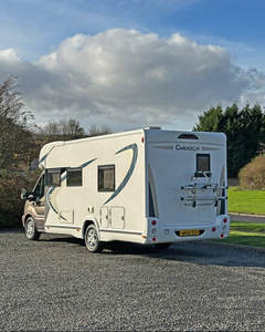 Autocaravana compacta blanca con detalles negros y diseño de puerta lateral - Product Image 6