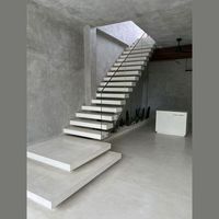 Escalier flottant sur mesure de conception architecturale, construit à partir de marches en bois et d'un garde-corps minimaliste en acier inoxydable