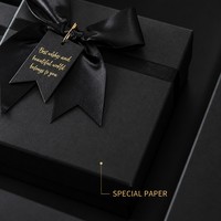 Boîte cadeau de luxe en carton rigide noir mat avec nœud satiné, élégante, monochrome, minimaliste, personnalisable pour boutique et souvenirs