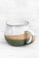 Taza de cerámica brillante con patrón en relieve y borde refinado, ideal para bebidas de desayuno o exhibición de estantes