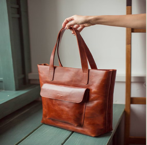 Ce sac fourre-tout en cuir marron décontracté porté par une femme avec un sous-verre en marbre est maintenant disponible à des prix de gros. - Product Image 2