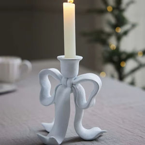 Whimsical white ceramic bow-shaped taper holder for a romantic <b>aesthetic</b>. Available at wholesale prices. - Product Image 1