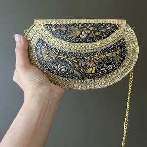 An elegant gold-toned clutch covered in a detailed gingko leaf pattern with a striking skull clasp. Available at wholesale price - Product Image 4