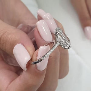 Anillo de compromiso de moissanita de corte esmeralda de lujo de 6 quilates en oro blanco con doble halo invisible de cuatro puntas y banda de media eternidad - Product Image 2