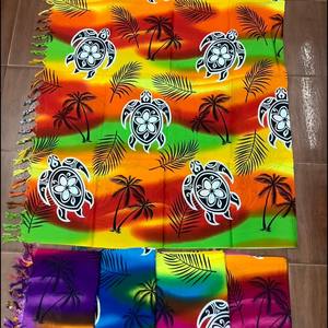 Una variedad de hermosos y coloridos pareos de rayón en diseños hawaianos y polinesios listos para su envío inmediato. - Product Image 3