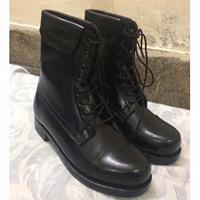 une paire de bottes en cuir noir, peut-être des bottes de pilote ou de pilote de ligne