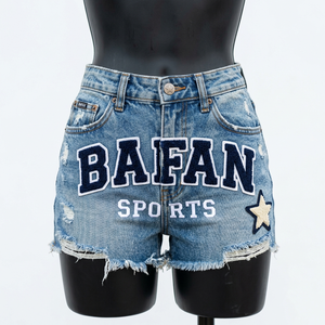 Shorts en jean pour femme 320 GSM en coton denim bleu clair, effet usé, ourlet brut, patch en chenille, logo personnalisé - Product Image 1