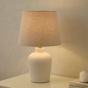 Coastal-style lamp with a ceramic pebble texture and linen shade. Neutral, modern design. Available at wholesale prices - Product Image 6