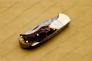 Couteau utilitaire pliant artisanal en acier Damas, fabrication OEM, manche en corne de cerf naturelle, contreforts en acier, lame à bord dentelé et pointe tombante - Product Image 4