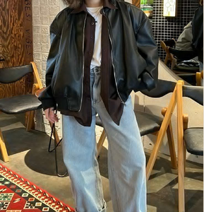 Chaqueta de cuero negra extragrande sobre una camiseta blanca y camisa abotonada con pantalones vaqueros de pierna ancha. Disponible a precios de mayoreo. - Product Image 1