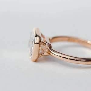 East West Emerald Cut CZ Anillo solitario en oro rosa | Banda de compromiso con bisel de 6x8mm - Product Image 2