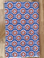 T-shirt pour enfants avec motifs floraux orange et blanc sur fond bleu, créant un design joyeux et ludique, parfait pour tous les jours.
