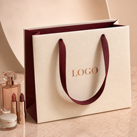 Sac en papier de luxe personnalisé avec logo en feuille d'aluminium pour l'emballage de rouge à lèvres, de flacons de parfum et de sérums de soin de la peau