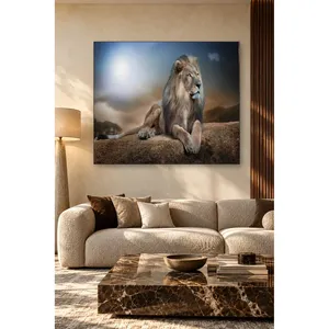 Impression sur toile : Lion Fida assis sur une roche sous un ciel bleu éclatant - Product Image 1