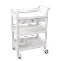 Chariot utilitaire médical blanc en ABS avec étagères, un tiroir, deux bacs, barrières de sécurité et surface de travail lisse pour usage clinique