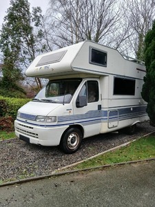 Camping-car d'occasion blanc à rayures bleues pour vacances en famille, véhicule de tourisme avec cabine supérieure - Product Image 1