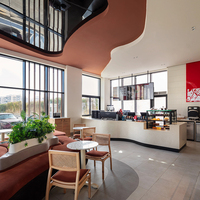 Moderne Café-Einrichtung mit Rattanstühlen, Gebogener Terrazzo-Theke und Rost-Inselsofa für Premium-Marken-Cafés