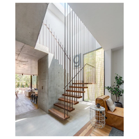 Escalier flottant moderne en bois massif avec poutre en acier dissimulée dans le mur et rampe en verre pour appartement