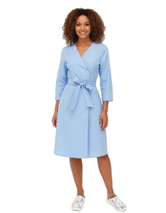 Alegre Mujer Afroamericana con Uniforme Médico Azul Claro, Vestido Tipo Bata con Cinturón de Lazo y Zuecos Estampados - Product Image 1