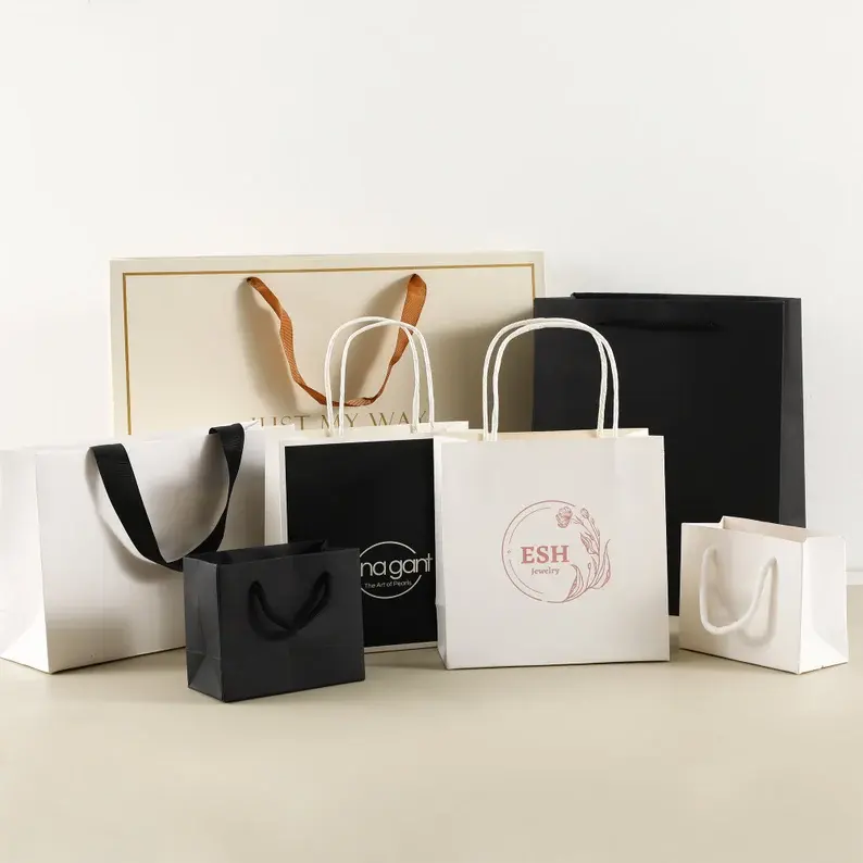 कस्टम लोगो थोक लक्जरी पेपर बैग पैकेजिंग उपहार बैग बैग पपेल शॉपिंग कार्डबोर्ड बैग कपड़ों के लिए हैंडल के साथ