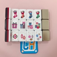 Tuiles de Mahjong de Noël populaires avec motifs rouges, verts, roses et dorés et icônes hivernales pour un ensemble de jeu de Mahjong décoratif de Noël