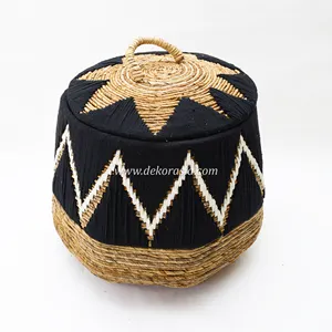 黒の背景に綿糸のアクセサリーとバナナ樹皮から作られたハンドルで織られたランドリーバスケット