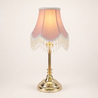 Lampe de chevet élégante sans fil avec abat-jour en tissu rose à pompons perlés et base dorée pour les intérieurs de boutiques