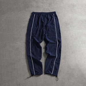 Pantalon large pour homme haut de gamme, coupe ample, base blanche avec bandes latérales noires, cordon de serrage, ajustement confortable. - Product Image 1