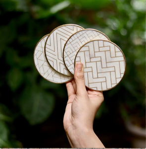Quatre sous-verres circulaires en marbre blanc avec un motif géométrique élégant en laiton sont disponibles en gros à des prix uniques. - Product Image 1