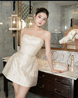 Belle et élégante en une robe blanche courte avec un motif en relief saisissant, fabriquée au Vietnam