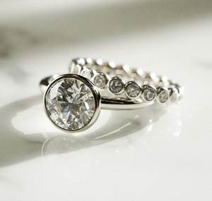 แหวนหมั้นเพชรทรงกลม 1.5 กะรัต เพชรเลี้ยงในห้องปฏิบัติการ ประดับแบบ Bezel Set Solitaire พร้อมวงแหวน Eternity Band ขนาด 2 มม. ชุดแหวนแต่งงานสำหรับเจ้าสาว งานละเอียดประณีต - Product Image 1