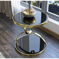 Table d'appoint au design unique en marbre et métal, marbre noir rond avec finition dorée, structure de table de forme unique