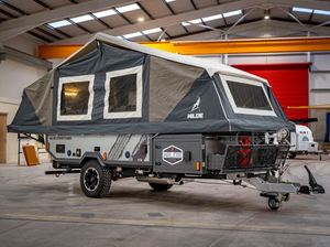 Caravane de luxe pour le camping, dotée d'un lit queen size, d'un coin repas en cuir et d'une salle de bain complète pour les voyageurs. - Product Image 5