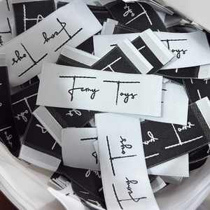 ผ้าทอป้ายยี่ห้อตามสั่งพร้อมโลโก้2X5ซม. พับตรงกลางพับได้ด้วยเลเซอร์ - Product Image 5