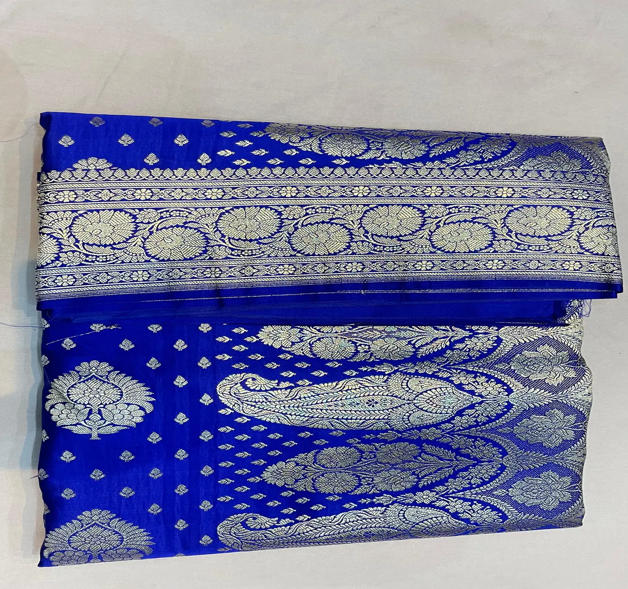 custom made in royal blue coloured floral designed brocade silk saree made with gold borders ideal for resale by clothing stores