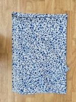 Tela de algodón puro premium con estampado floral índigo presenta elegantes patrones de ramas de flores azules bellamente estampados sobre un fondo blanco.