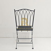 Chaise pliante en fer noir avec dossier arqué gothique pour la location de mobilier de mariage et d'événements