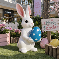 Sculpture de lapin de dessin animé tenant un œuf tacheté avec de longues oreilles et une forme d'animal ludique pour la décoration extérieure sur le thème de Pâques