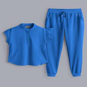 Ensemble de gommage médical deux pièces bleu pour femme avec haut sans manches et pantalon de survêtement à cordon - Product Image 1