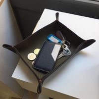 Plateau de service en cuir minimaliste pour support polyvalent avec des côtés forts et des tons neutres se mélangeant avec n'importe quel décor intérieur