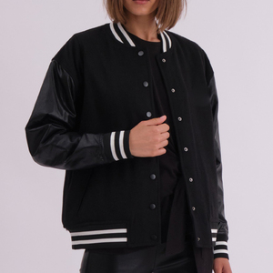 Veste de style universitaire noire pour femmes, manches en cuir, bordure côtelée rayée, style urbain surdimensionné, mode streetwear. - Product Image 1